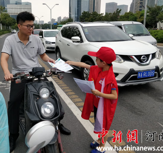 小志愿者為路人發(fā)放綠色出行宣傳單,。連柏梁 小志愿者為路人發(fā)放綠色出行宣傳單,。連柏梁