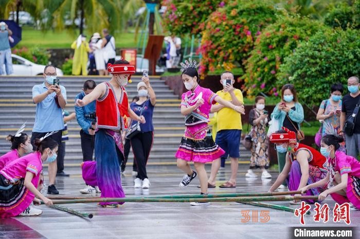 資料圖：三亞大小洞天旅游區(qū)入口，工作人員跳竹竿舞迎接游客,。 駱云飛 攝