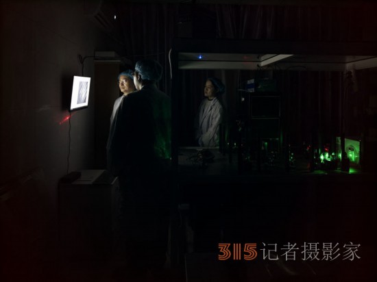 阮昊研究員（左）和他的學(xué)生趙苗（中）,、胡巧在上海光機(jī)所光學(xué)實(shí)驗(yàn)室,，利用國際首創(chuàng)的雙光束調(diào)控聚集誘導(dǎo)發(fā)光超分辨光存儲(chǔ)技術(shù)做寫入試驗(yàn)（2月29日攝）。